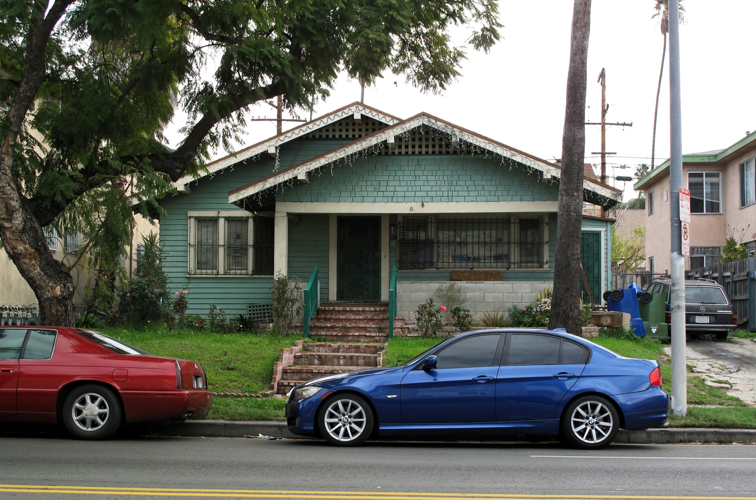 Green Craftsman bungalow with a shaded front porch in Los Angeles